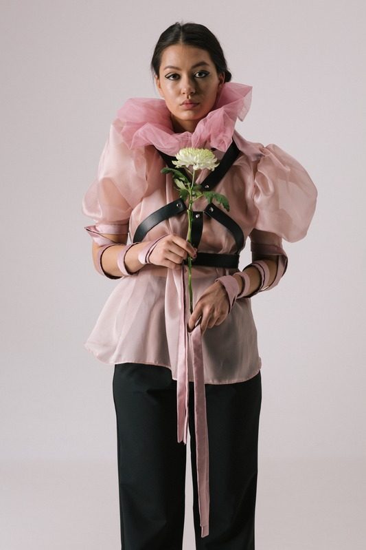 Pink blouse with harness, holding white flowers