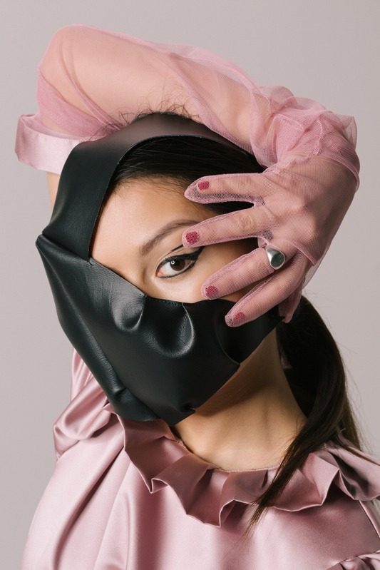 Black leather mask over a pink silk look