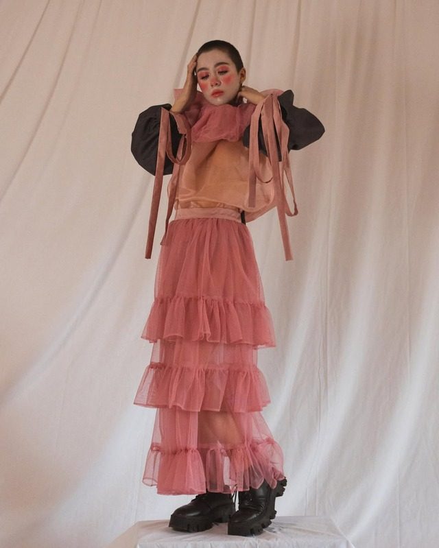 Pink tiered tulle look against a pink curtain